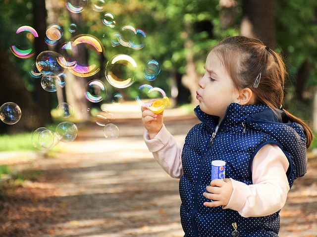 Imagen de una niña haciendo pompas de jabón