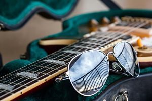 Imagen de una guitarra eléctrica y unas gafas de sol