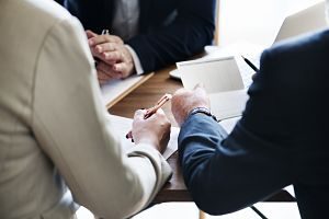 Imagen de unas personas firmando un documento