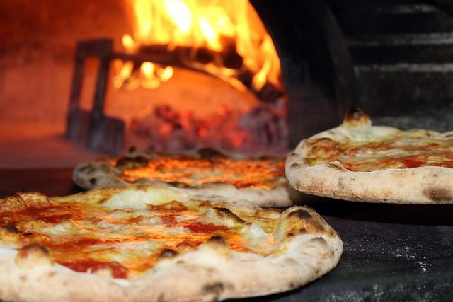 Imagen de unas pizzas al horno de leña