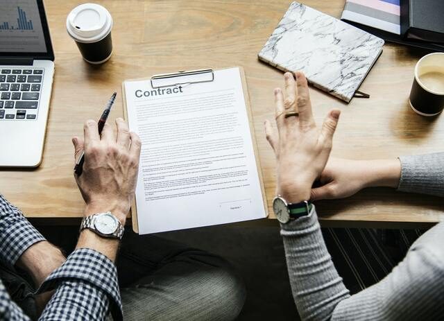 dos personas firmando un contrato